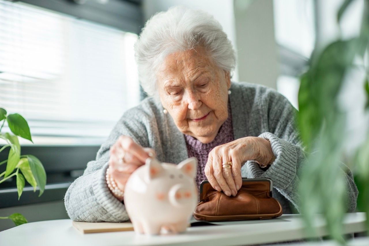 Woman sitting down in front of piggy bank